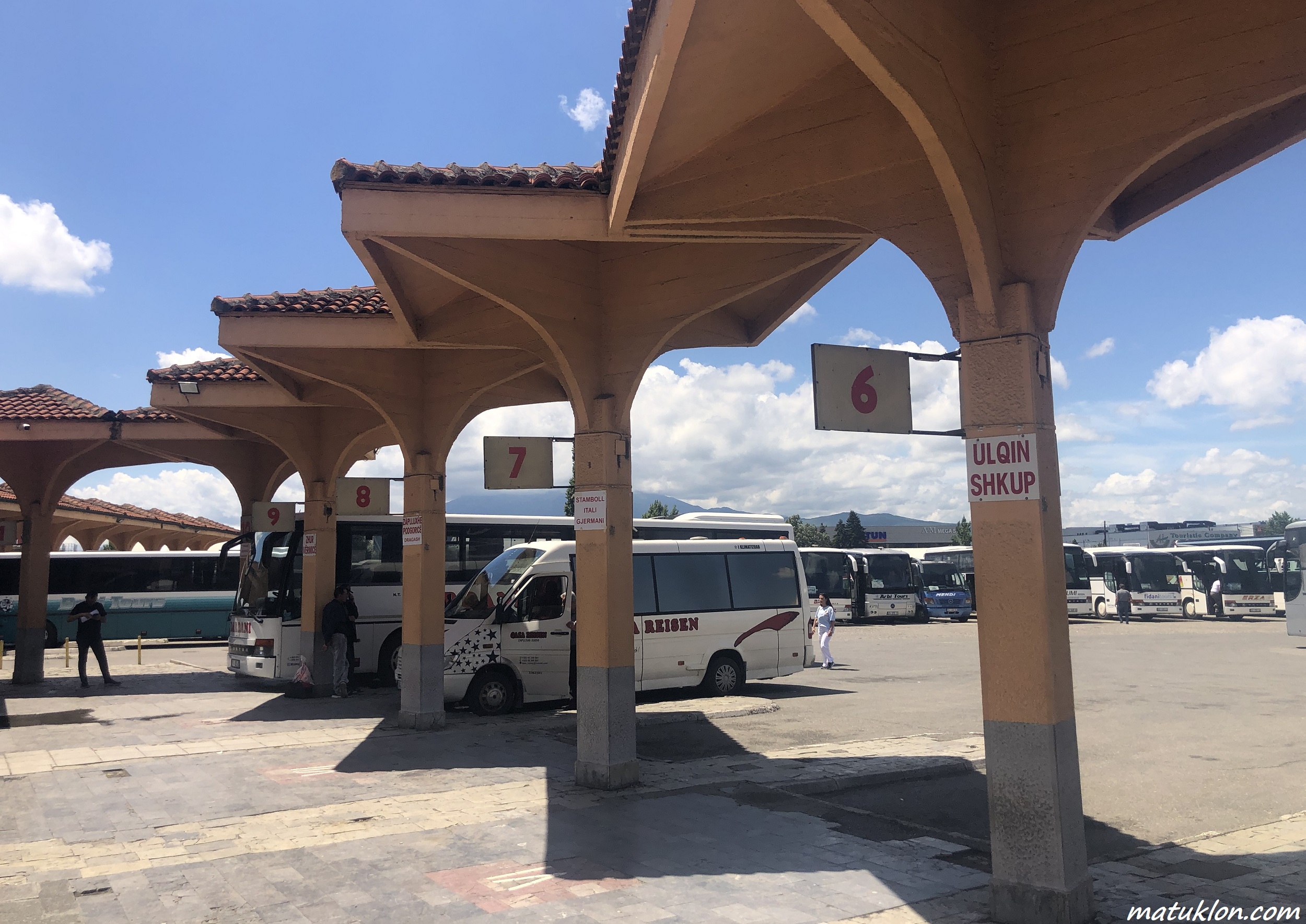 Bus station platforms numbered from 6 to 9 against blue sky with white clouds